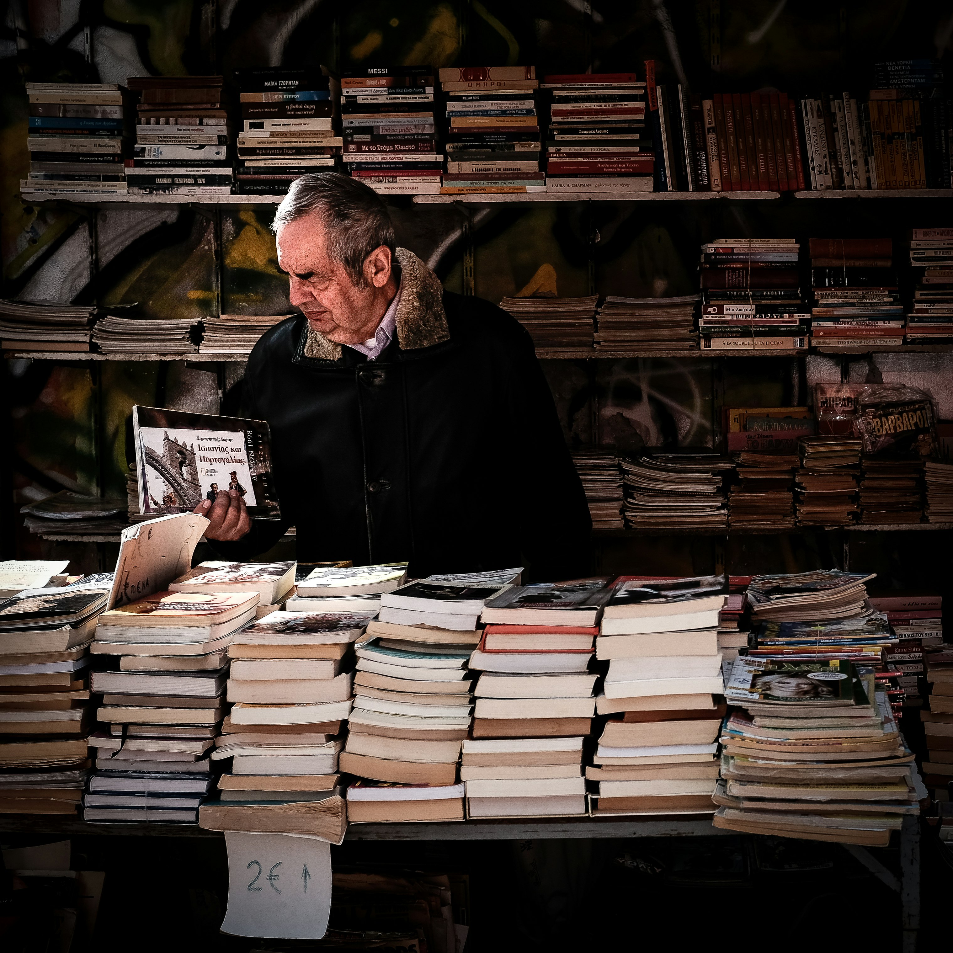 man holding book near library